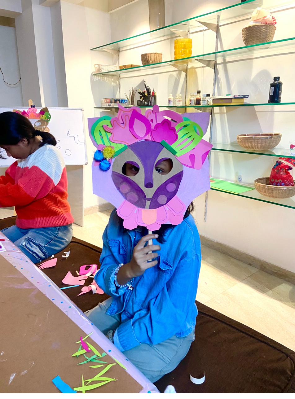 Child holding purple and pink lion mask
